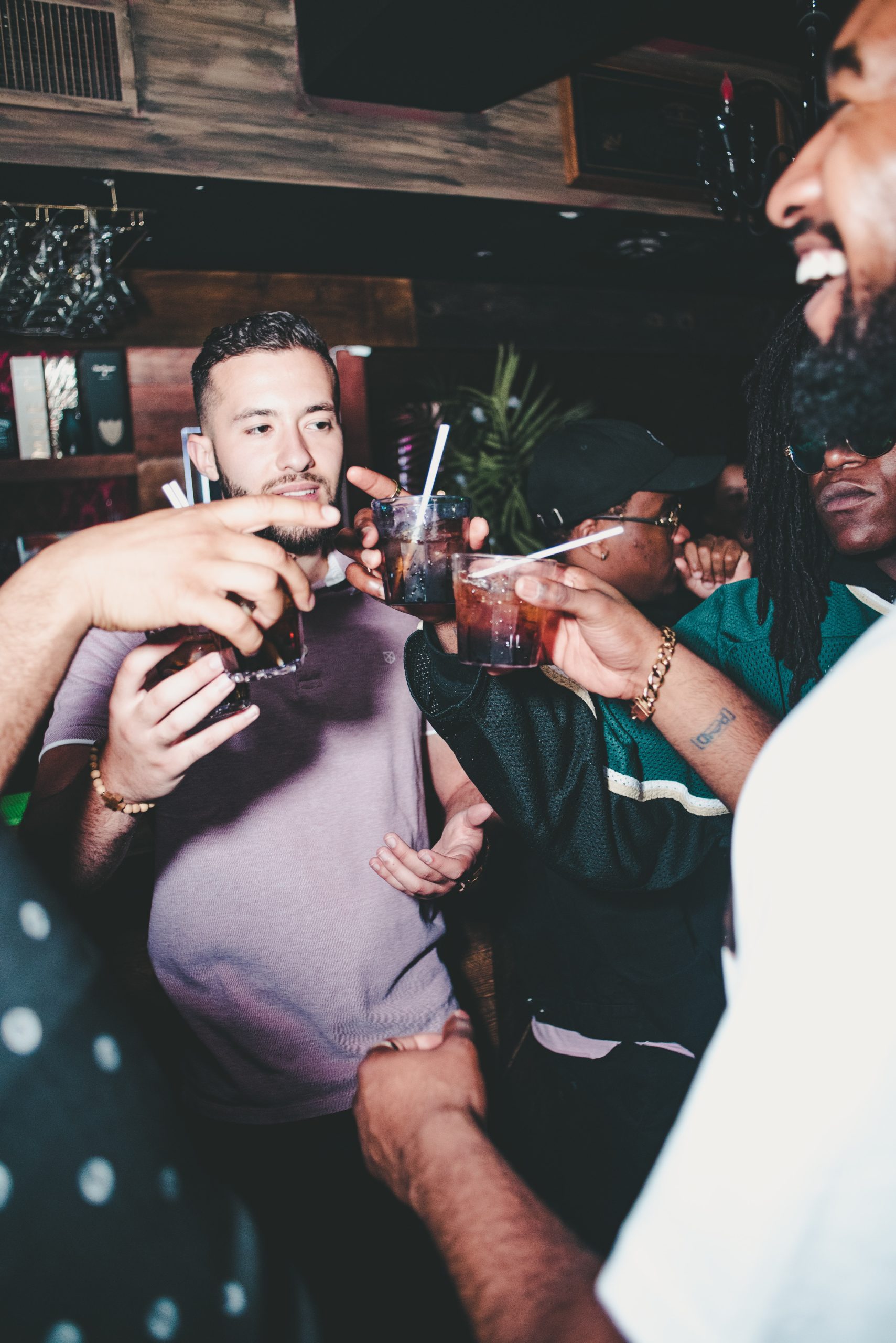 People at a bar having fun and cheering their drinks